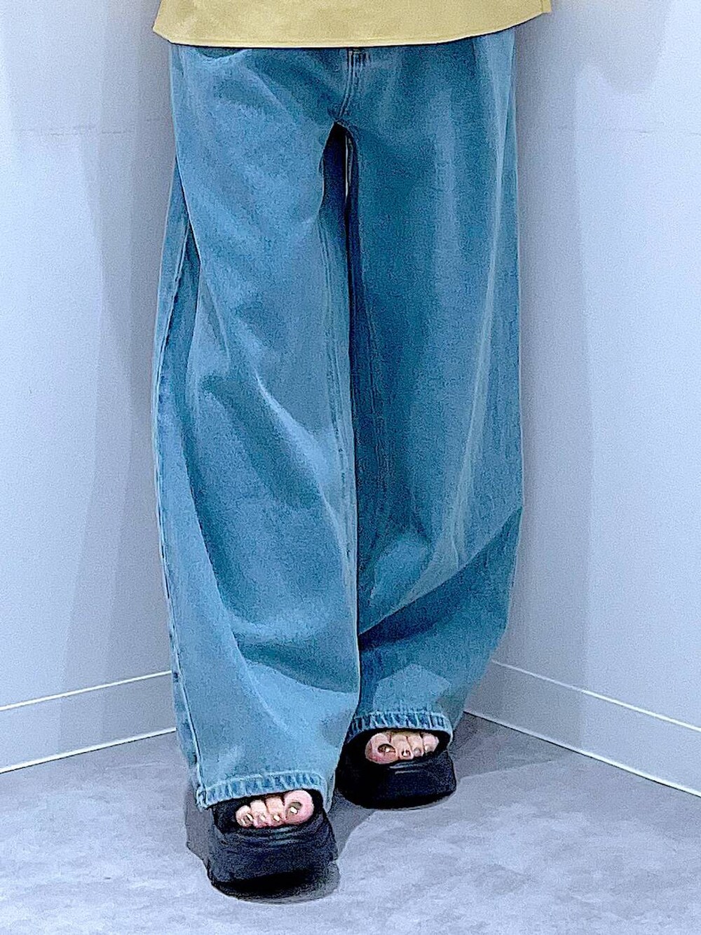 ブラック系のスニーカー、ブルー系のデニムパンツ、イエロー系のシャツ/ブラウスを着用したレディースの秋コーディネートの8枚目の写真