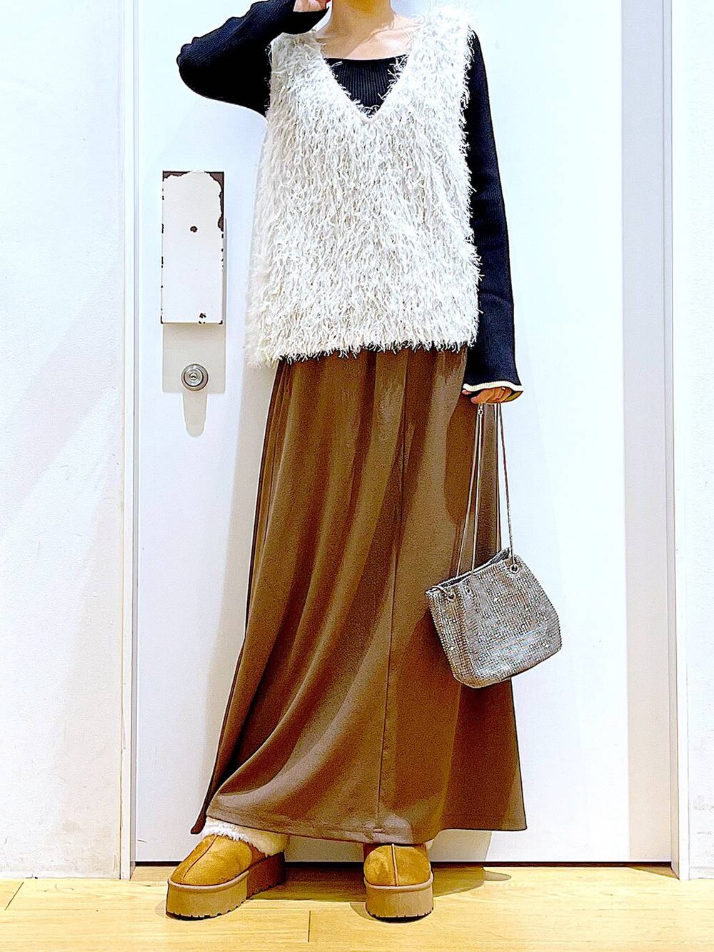 ブラック系のニット/セーター、グレー系のショルダーバッグ、ベージュ系のベストを着用したレディースの秋コーディネートの6枚目の写真