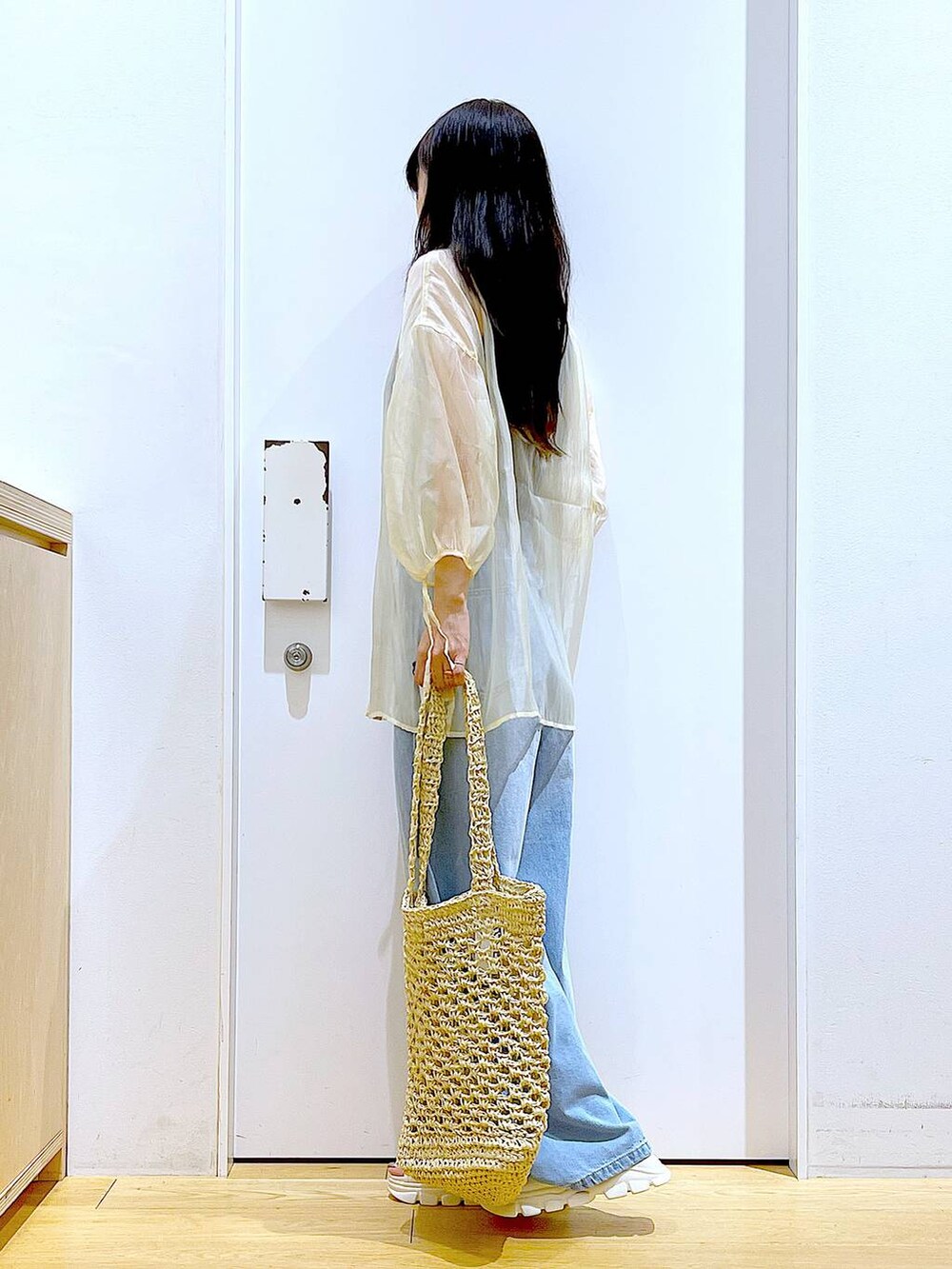 ホワイト系のサンダル、ホワイト系のトートバッグ、ブルー系のデニムパンツを着用したレディースの夏コーディネートの3枚目の写真