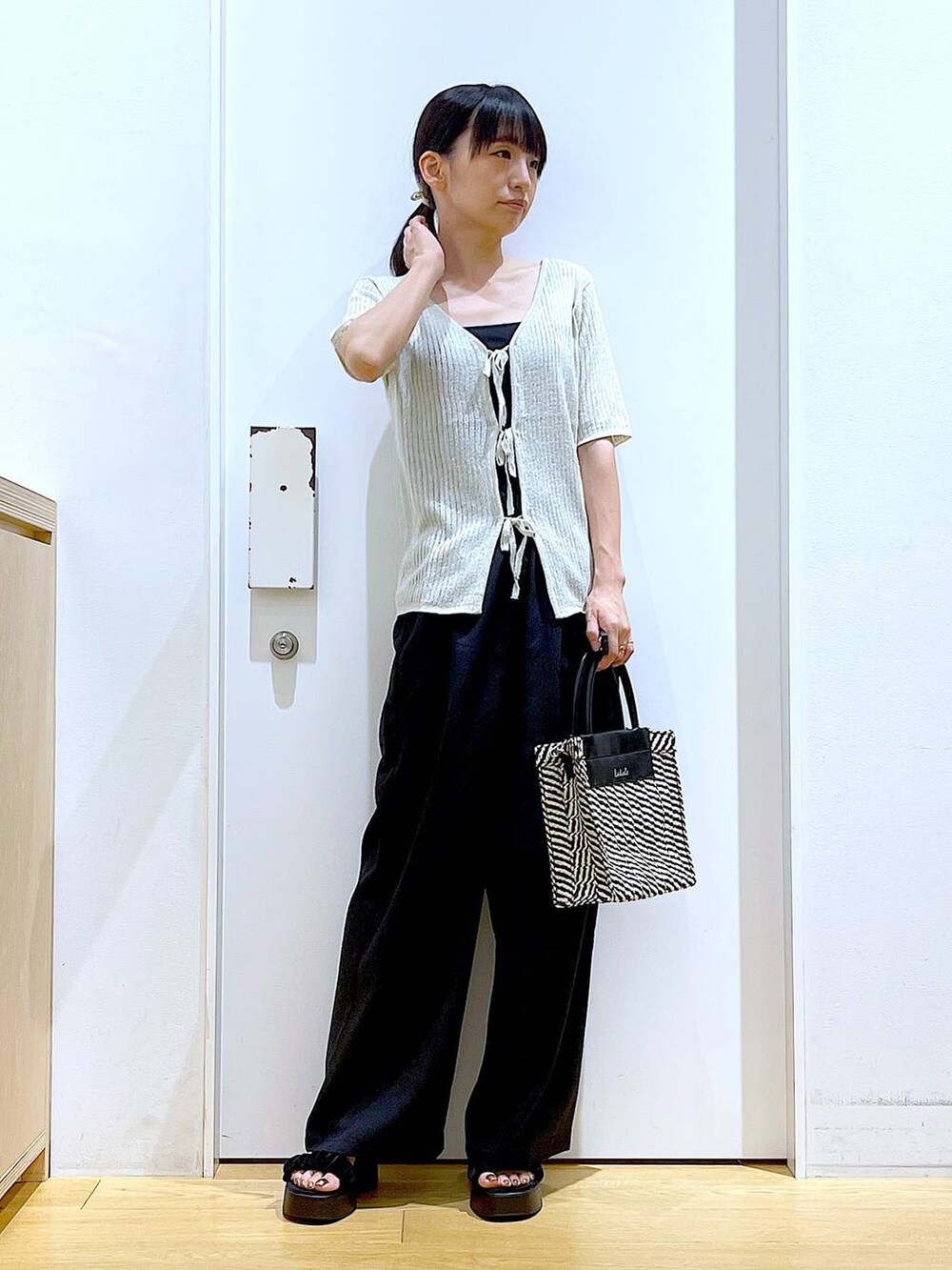 ブラック系のキャミソール、ブラック系のショルダーバッグ、ブラック系のサンダルを着用したレディースの夏コーディネートの2枚目の写真