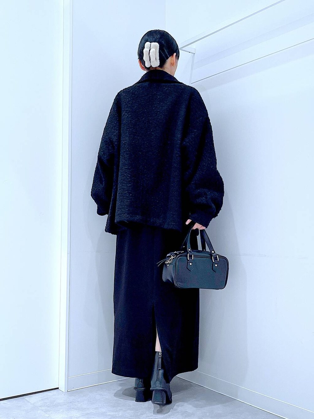 ブラック系のスカート、ブラック系のブルゾン、ブラック系のブーツを着用したレディースの冬コーディネートの5枚目の写真