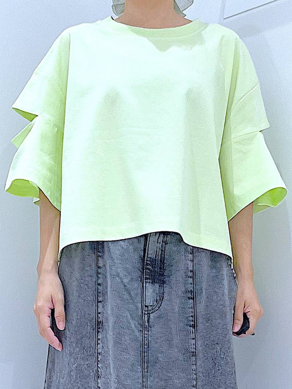 ブラック系のトートバッグ、ブラック系のサンダル、グリーン系のTシャツ/カットソーを着用したレディースの夏コーディネートの7枚目の写真