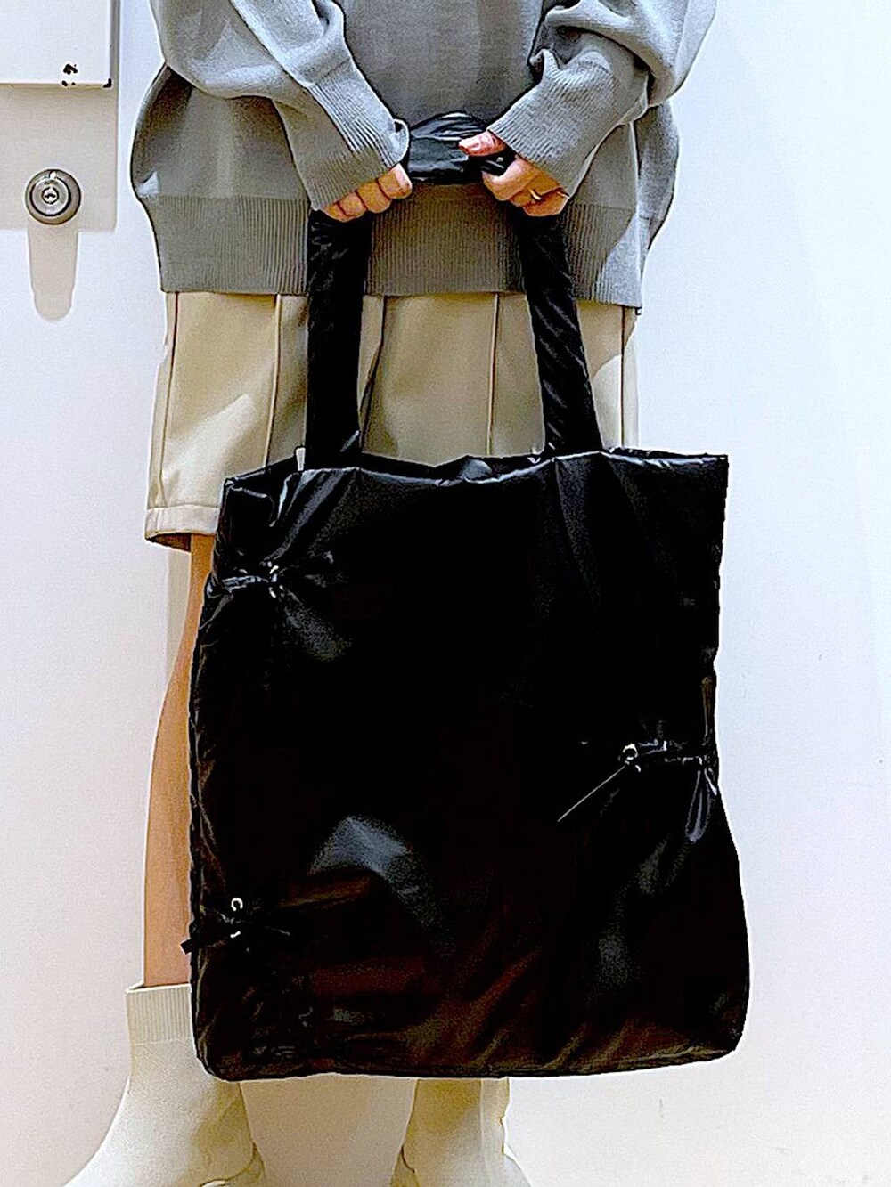 グレー系のニット/セーター、ブラック系のトートバッグ、ベージュ系のブーツを着用したレディースの冬コーディネートの9枚目の写真