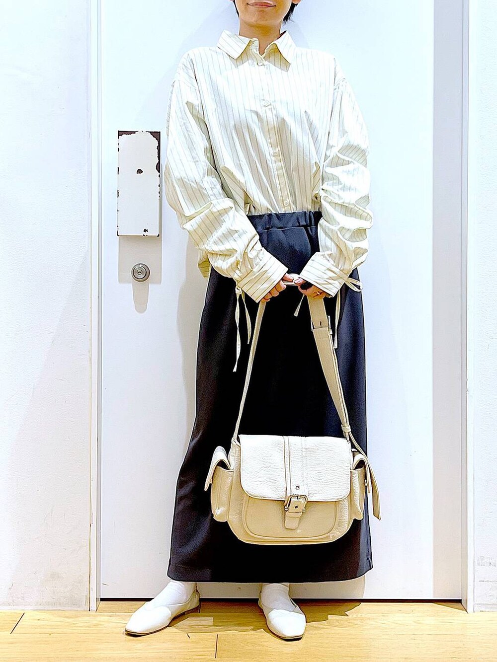 ホワイト系のパンプス、ベージュ系のシャツ/ブラウス、グレー系のスカートを着用したレディースの春コーディネートの6枚目の写真