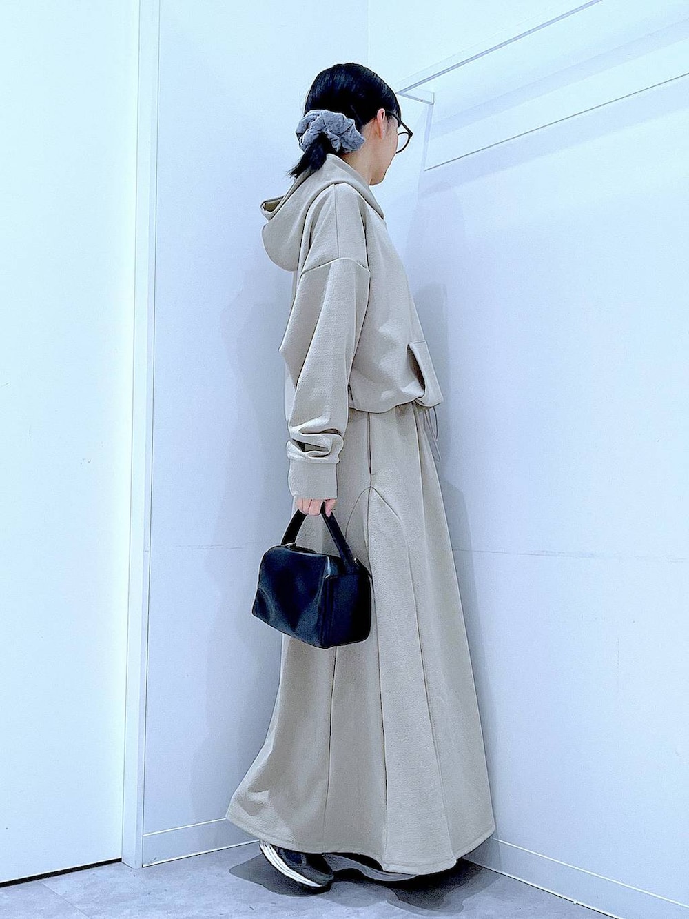 ブラック系のショルダーバッグ、グレー系のスウェット、グレー系のスカートを着用したレディースの冬コーディネートの4枚目の写真