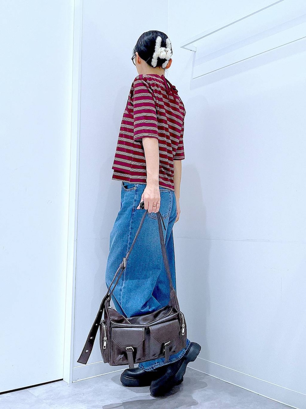 ブルー系のデニムパンツ、レッド系のTシャツ/カットソー、ブラック系のその他シューズを着用したレディースの秋コーディネートの3枚目の写真