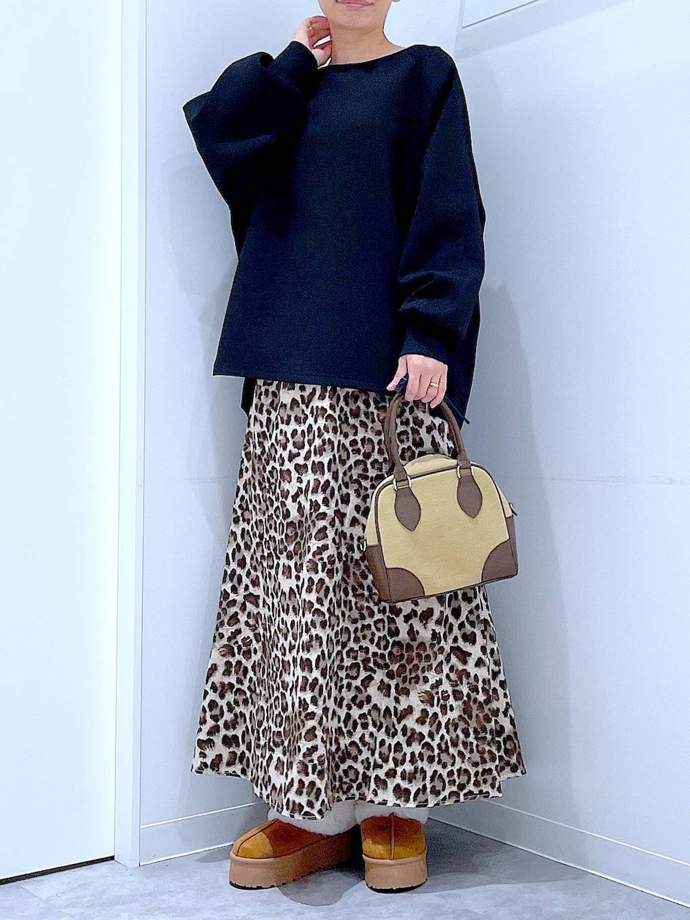 イエロー系のスリッポン、ベージュ系のハンドバッグ、ブラウン系のスカートを着用したレディースの秋コーディネートの6枚目の写真