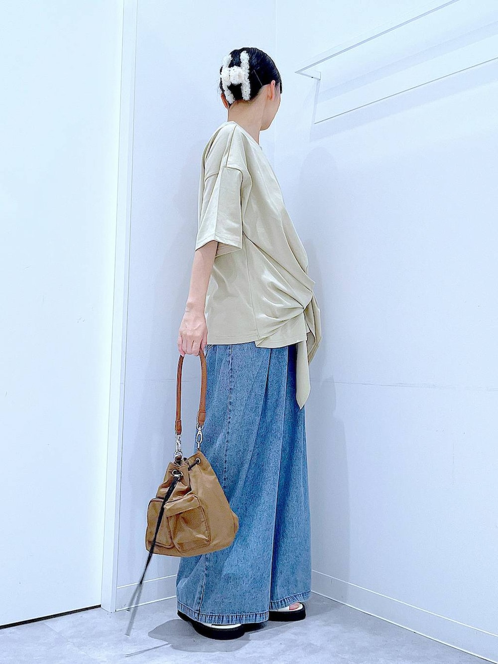 ホワイト系のサンダル、ブルー系のデニムパンツ、ブラウン系のショルダーバッグを着用したレディースの夏コーディネートの4枚目の写真