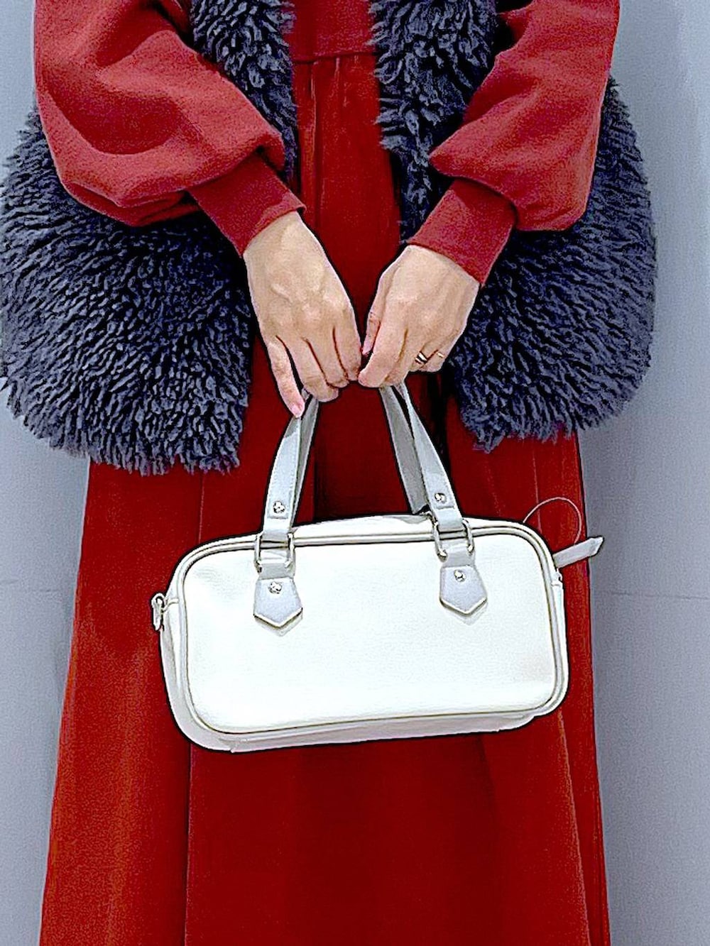 グレー系のベスト、ブラック系のブーツ、ホワイト系のショルダーバッグを着用したレディースの秋コーディネートの9枚目の写真