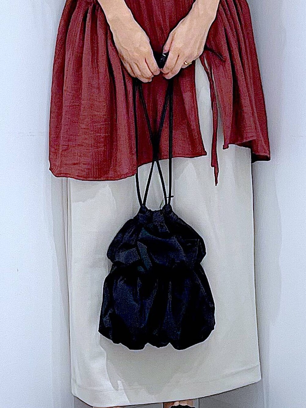 ブラック系のサンダル、ベージュ系のスカート、ブラック系のショルダーバッグを着用したレディースの秋コーディネートの9枚目の写真