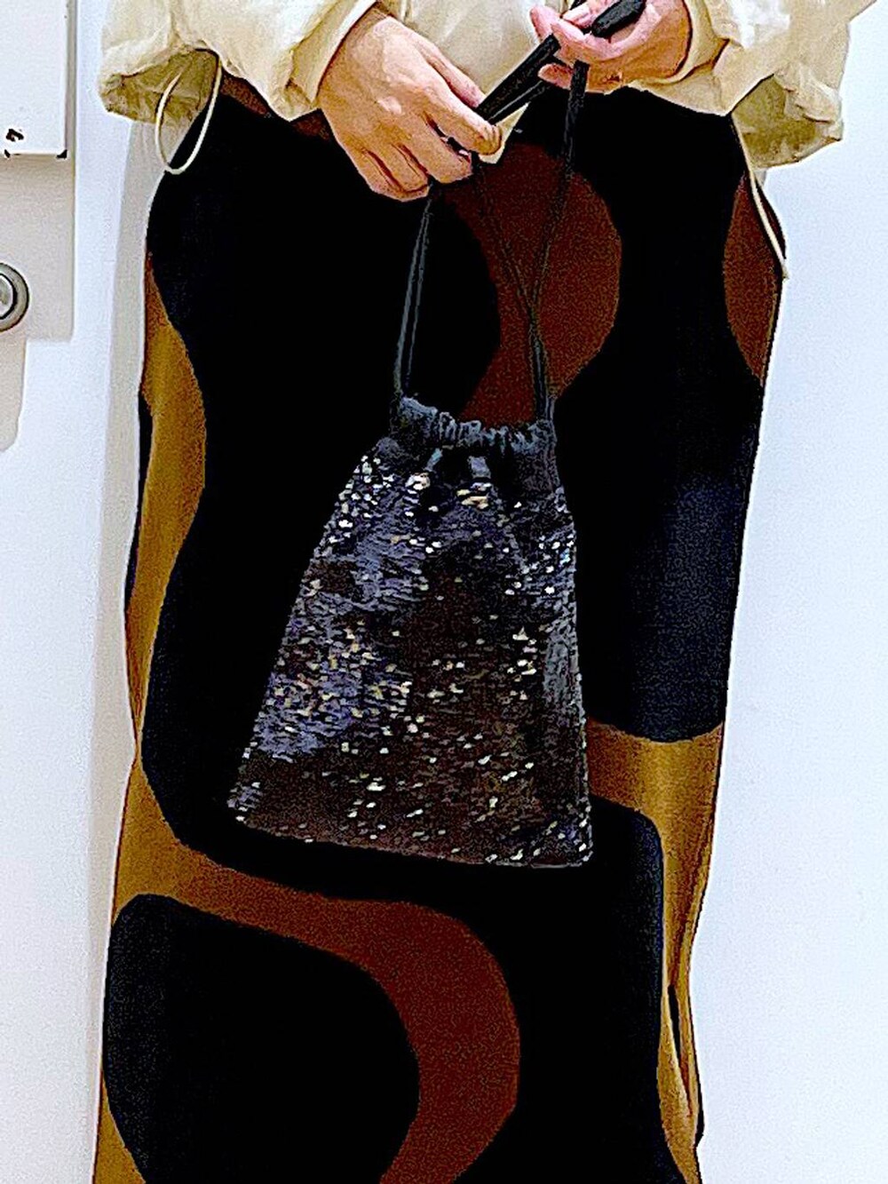 その他のスカート、ブラック系のショルダーバッグ、ブラック系のブーツを着用したレディースの冬コーディネートの9枚目の写真