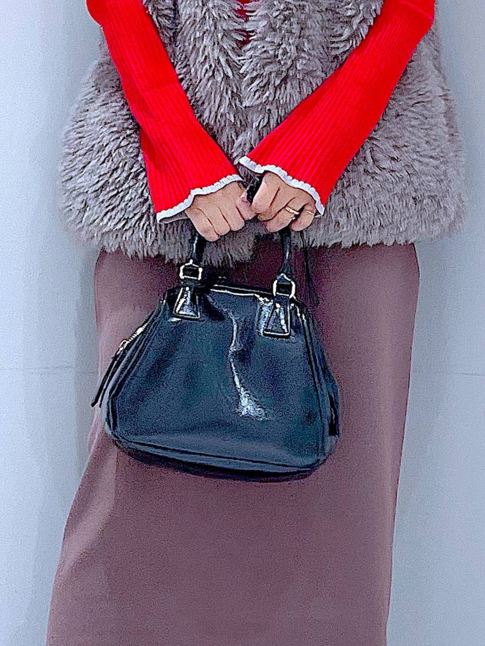 グレー系のベスト、レッド系のニット/セーター、ブラック系のブーツを着用したレディースの冬コーディネートの9枚目の写真