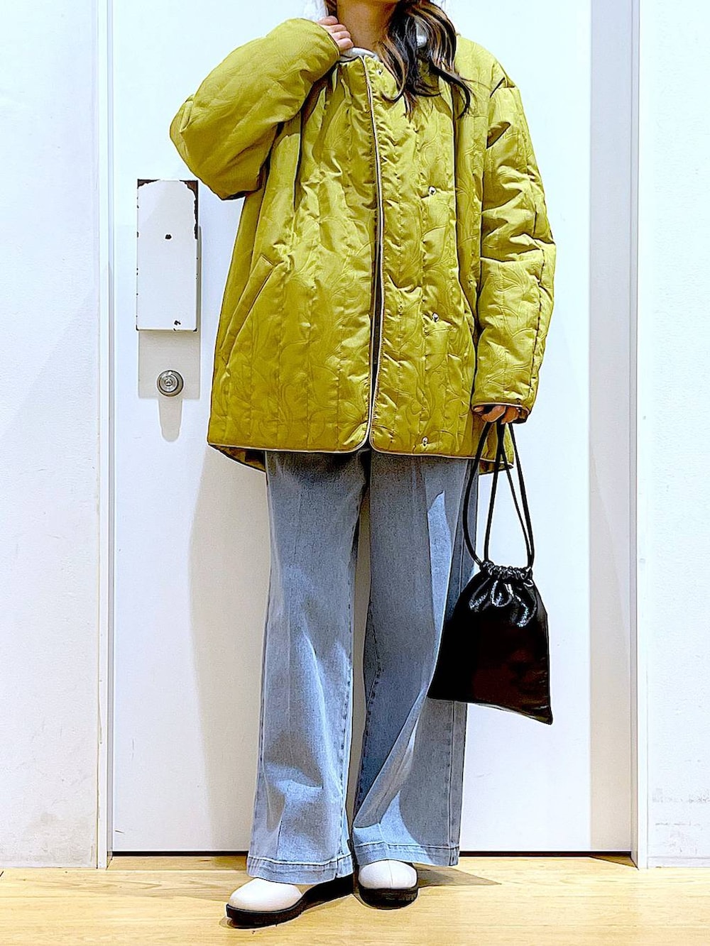 ブルー系のデニムパンツ、ベージュ系のブーツ、ベージュ系のパーカーを着用したレディースの冬コーディネートの6枚目の写真