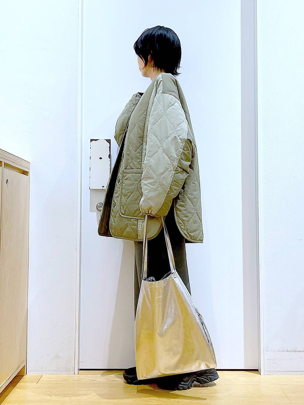 シルバー系のトートバッグ、グレー系のスカート、ブラック系のブーツを着用したレディースの秋コーディネートの3枚目の写真