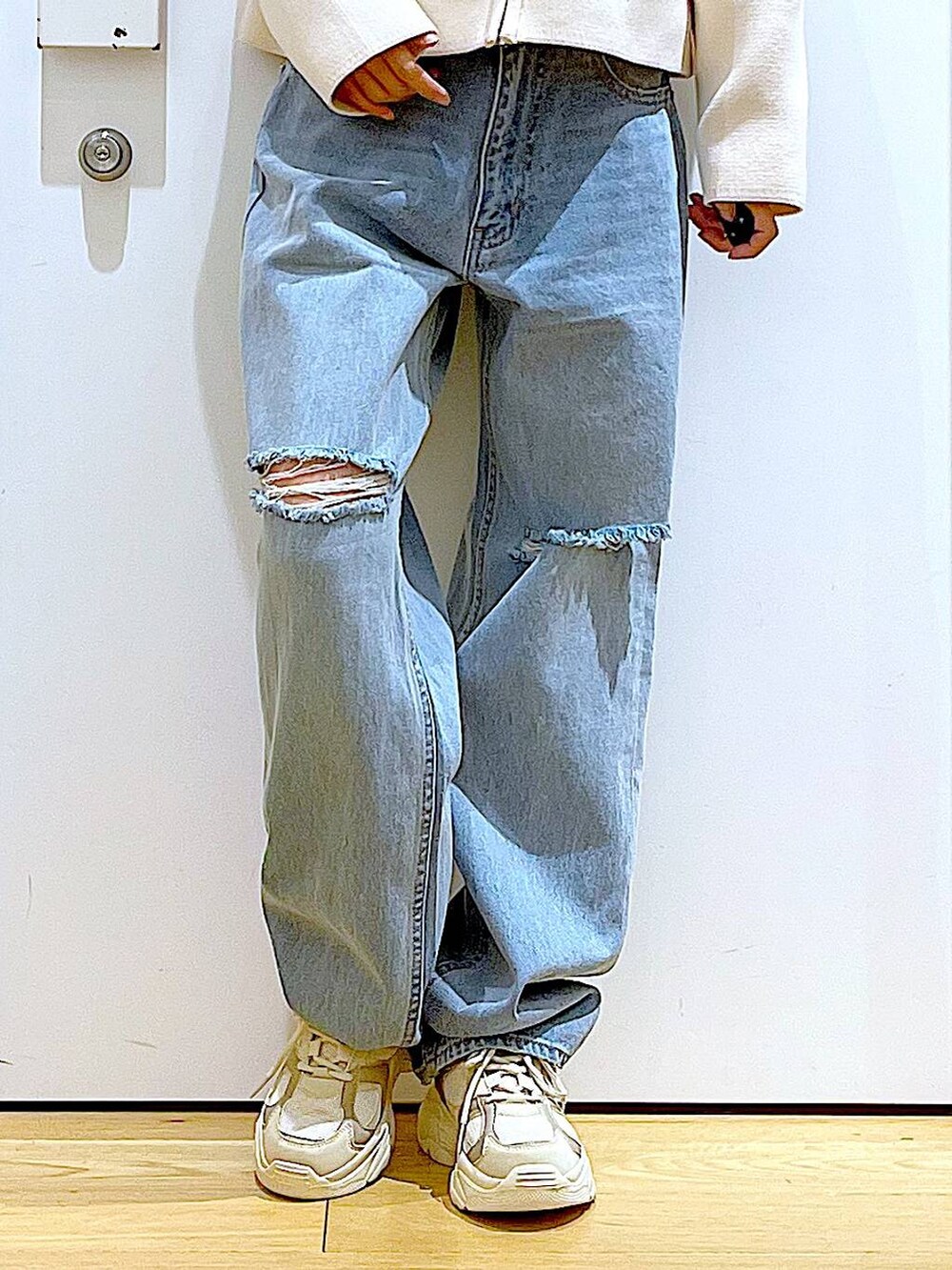 グリーン系のTシャツ/カットソー、ベージュ系のスニーカー、ブルー系のデニムパンツを着用したレディースの冬コーディネートの8枚目の写真