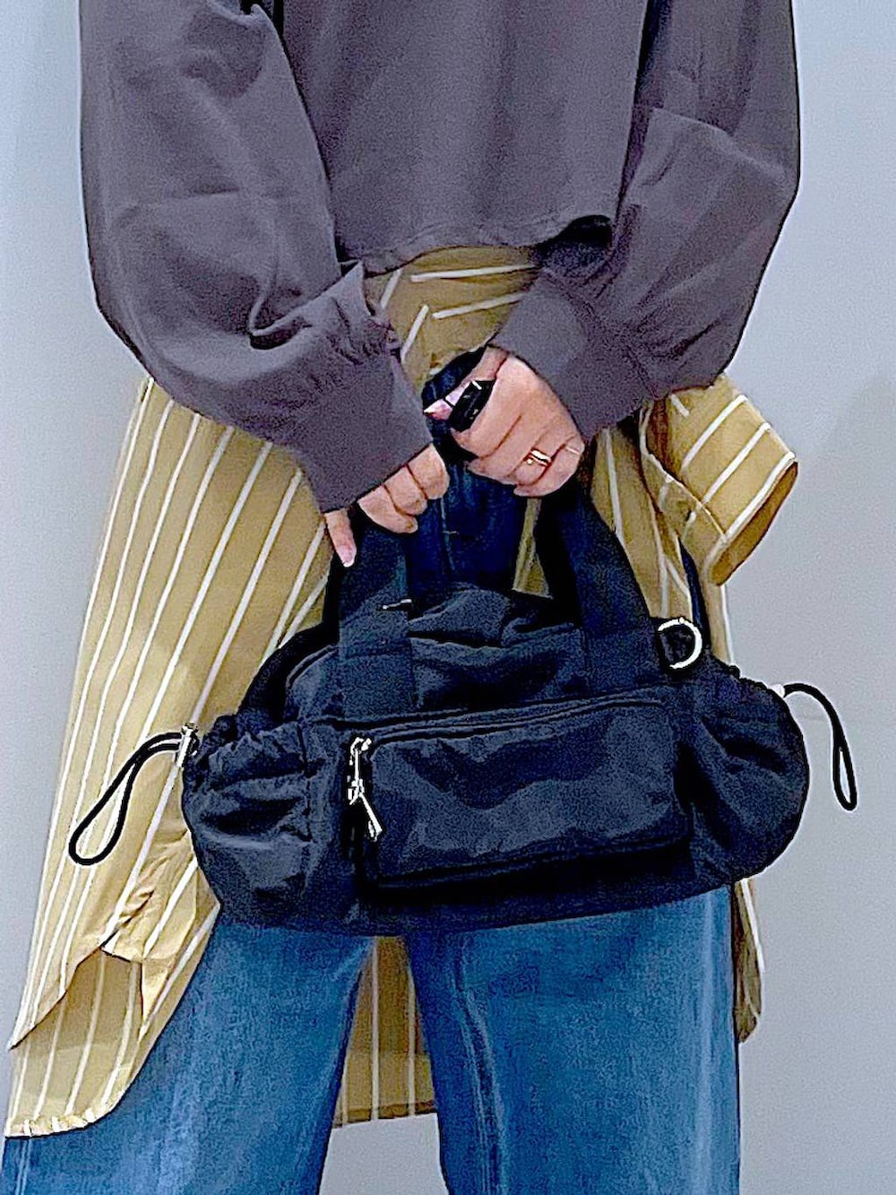 ブルー系のデニムパンツ、イエロー系のシャツ/ブラウス、グレー系のTシャツ/カットソーを着用したレディースの秋コーディネートの9枚目の写真