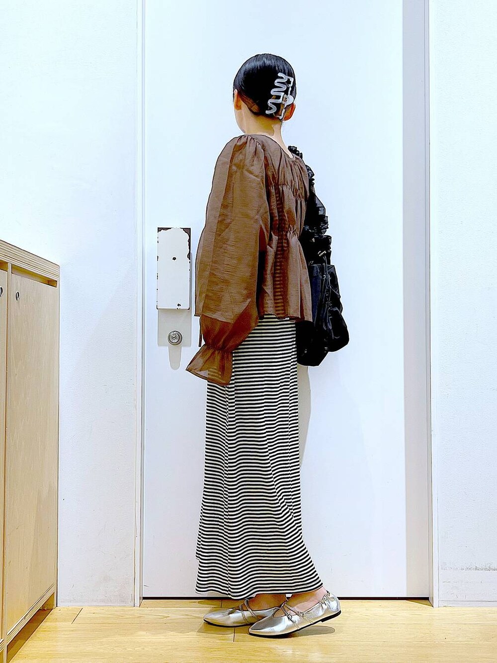 ブラック系のワンピース、シルバー系のパンプス、ブラック系のショルダーバッグを着用したレディースの夏コーディネートの3枚目の写真