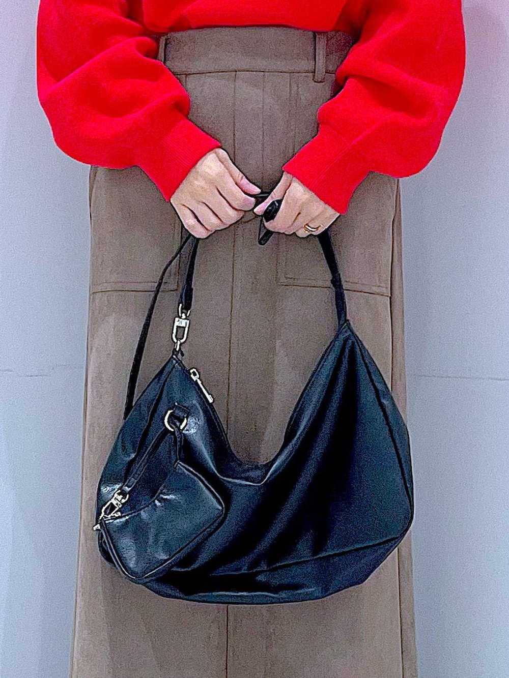 レッド系のニット/セーター、ブラック系のブーツ、ブラック系のショルダーバッグを着用したレディースの冬コーディネートの9枚目の写真