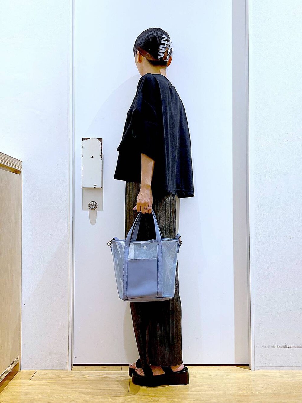 ブラック系のサンダル、ブルー系のトートバッグ、ブラック系のTシャツ/カットソーを着用したレディースの秋コーディネートの3枚目の写真