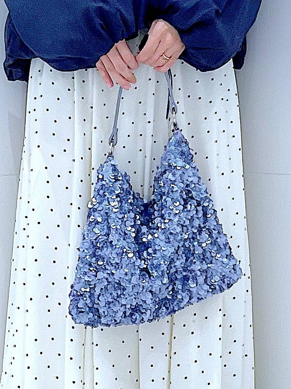 ブルー系のブルゾン、ブラック系のTシャツ/カットソー、ホワイト系のスカートを着用したレディースの春コーディネートの9枚目の写真