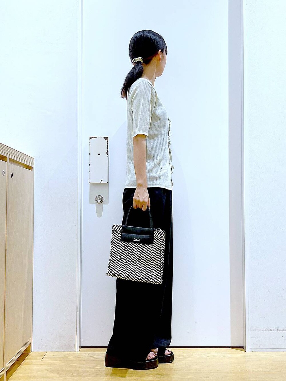 ブラック系のキャミソール、ブラック系のショルダーバッグ、ブラック系のサンダルを着用したレディースの夏コーディネートの4枚目の写真