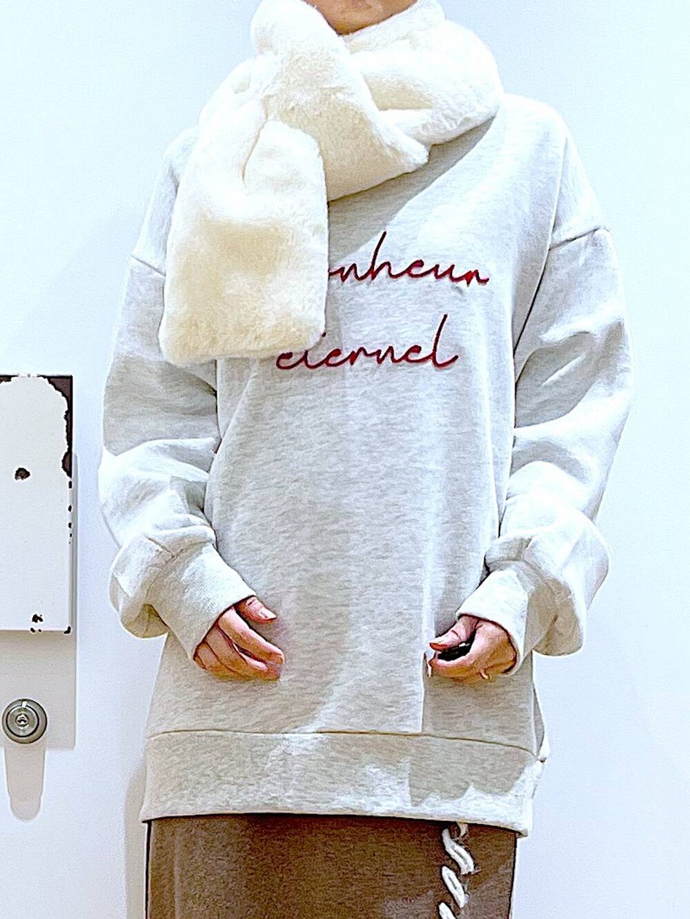 ブラック系のショルダーバッグ、ブラック系のブーツ、ブラウン系のスカートを着用したレディースの冬コーディネートの7枚目の写真