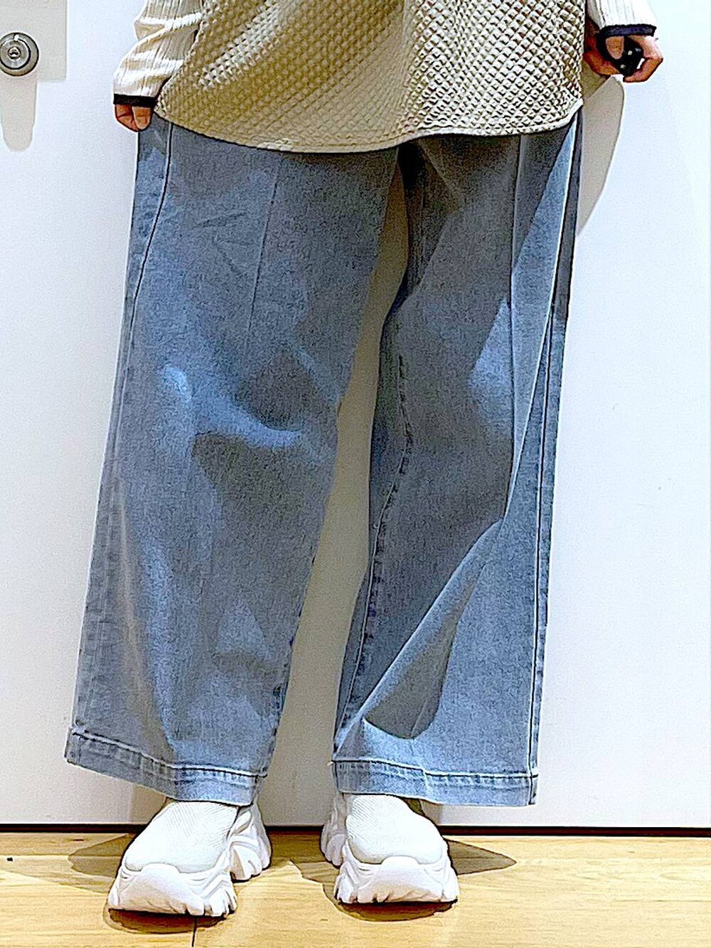 ブルー系のショルダーバッグ、ブルー系のデニムパンツ、ベージュ系のニット/セーターを着用したレディースの春コーディネートの8枚目の写真