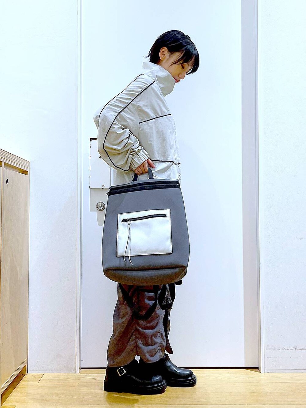 ブラック系のブーツ、グレー系のバックパック/リュック、グレー系のブルゾンを着用したレディースの秋コーディネートの4枚目の写真