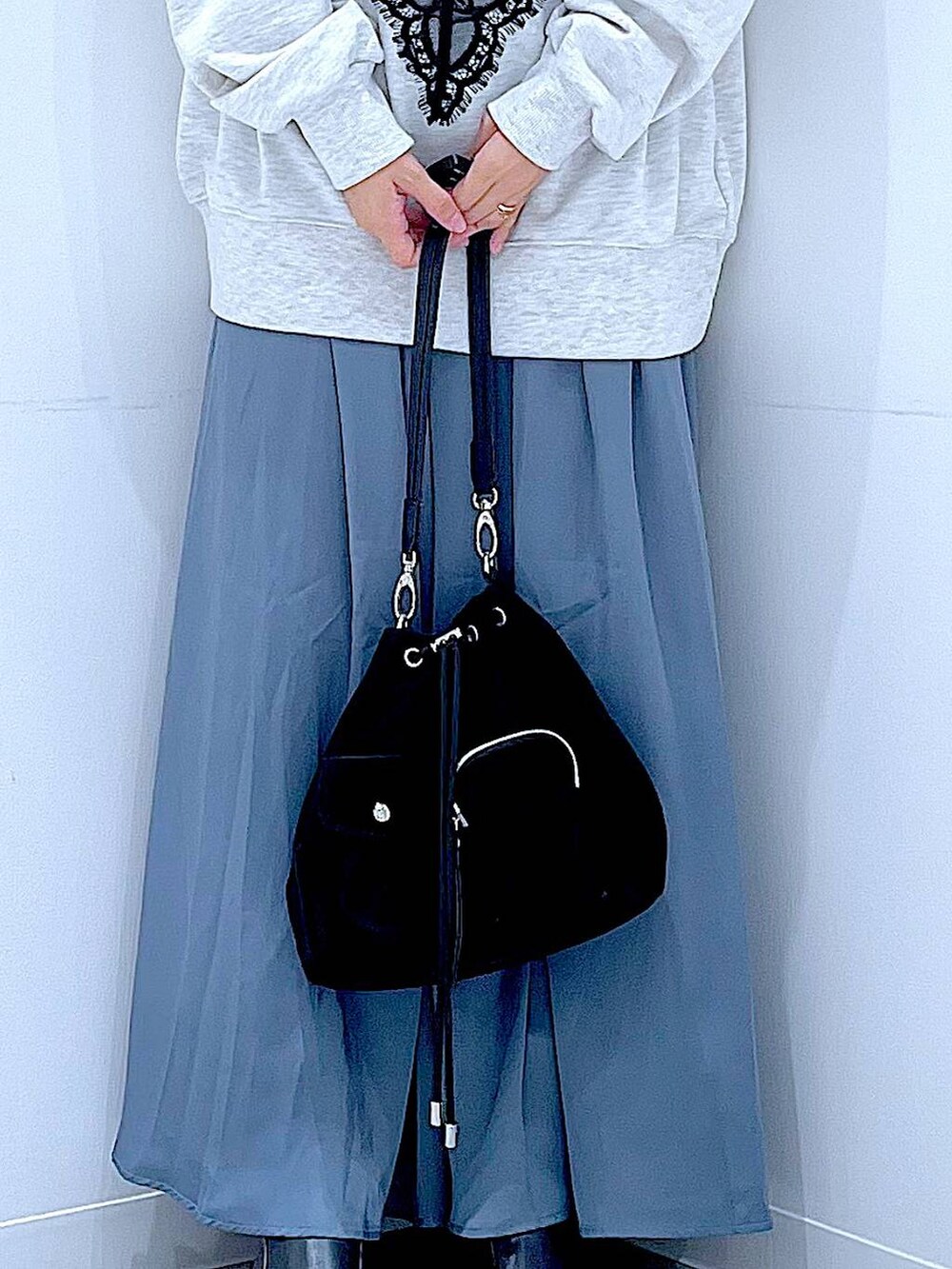 ブラック系のショルダーバッグ、ブラック系のブーツ、ベージュ系のスウェットを着用したレディースの冬コーディネートの9枚目の写真