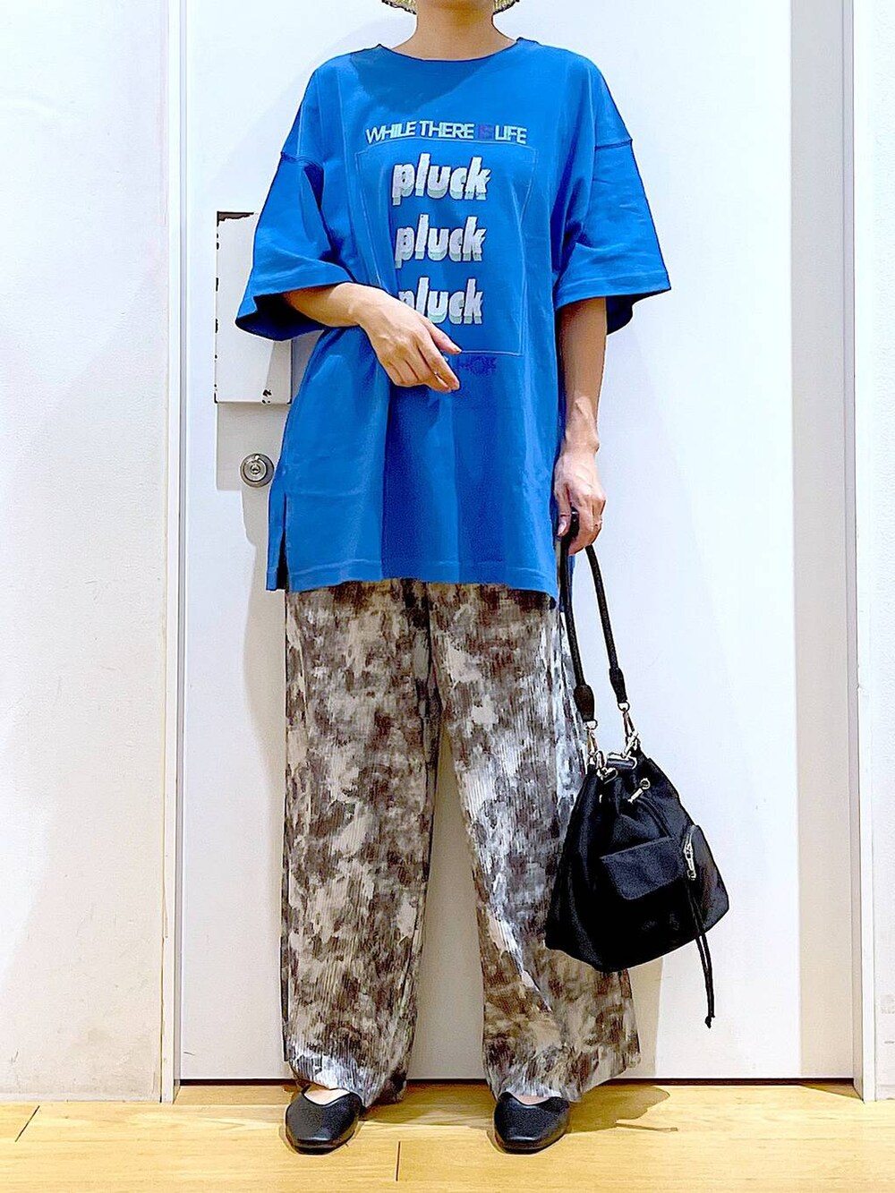 ブラック系のパンプス、グレー系のその他パンツ、ブルー系のTシャツ/カットソーを着用したレディースの春コーディネートの6枚目の写真