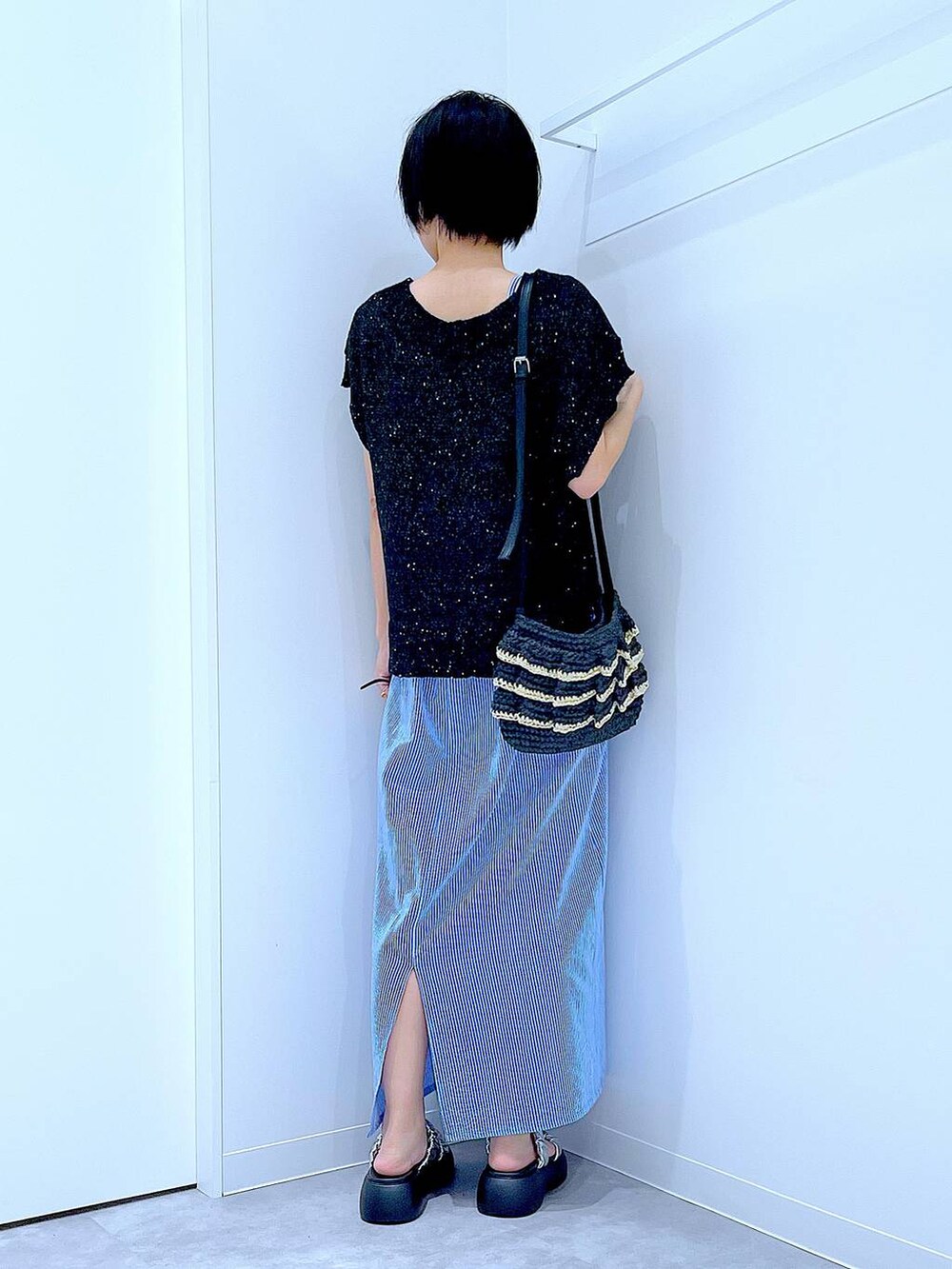 ブラック系のショルダーバッグ、シルバー系のサンダル、ブラック系のベストを着用したレディースの夏コーディネートの5枚目の写真