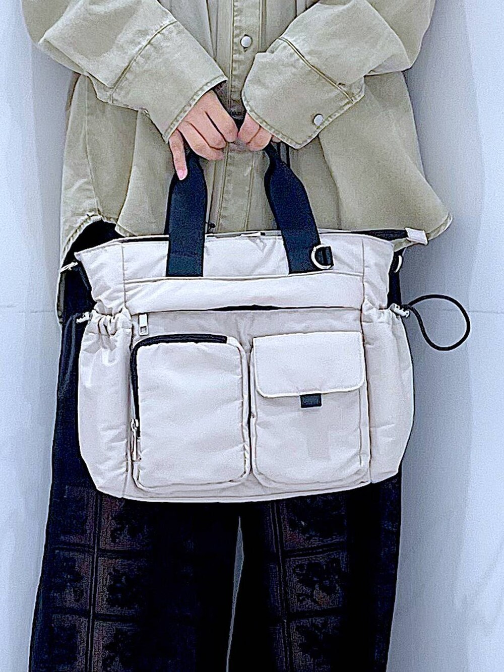 ホワイト系のトートバッグ、ベージュ系のシャツ/ブラウス、ブラック系のその他パンツを着用したレディースの春コーディネートの9枚目の写真
