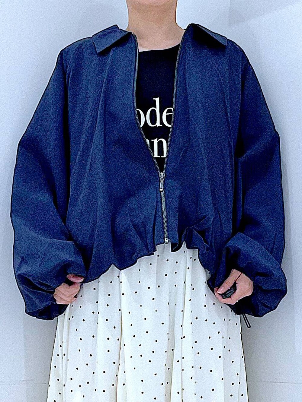 ブルー系のブルゾン、ブラック系のTシャツ/カットソー、ホワイト系のスカートを着用したレディースの春コーディネートの7枚目の写真