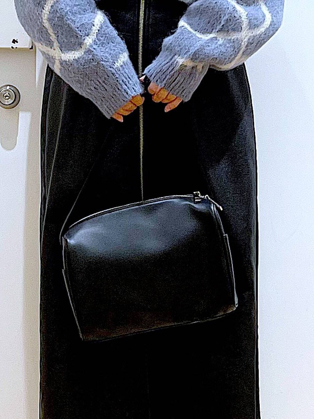 ブラック系のスカート、ブラック系のショルダーバッグ、ブラック系のブーツを着用したレディースの冬コーディネートの9枚目の写真