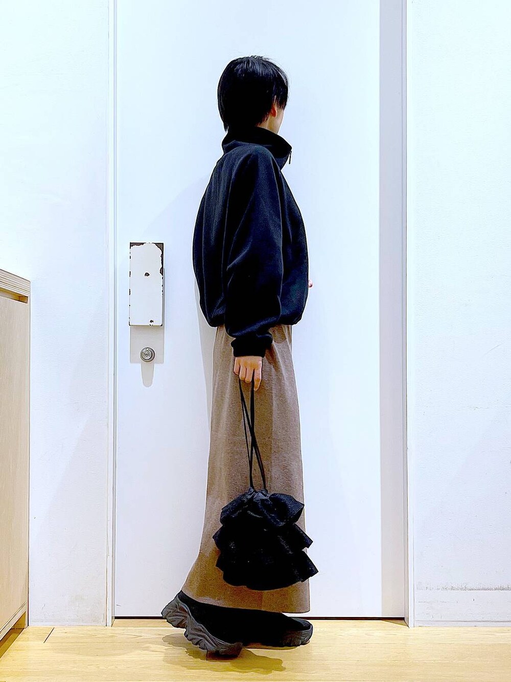 ブラック系のブーツ、ブラウン系のスカート、ブラック系のスウェットを着用したレディースの冬コーディネートの4枚目の写真