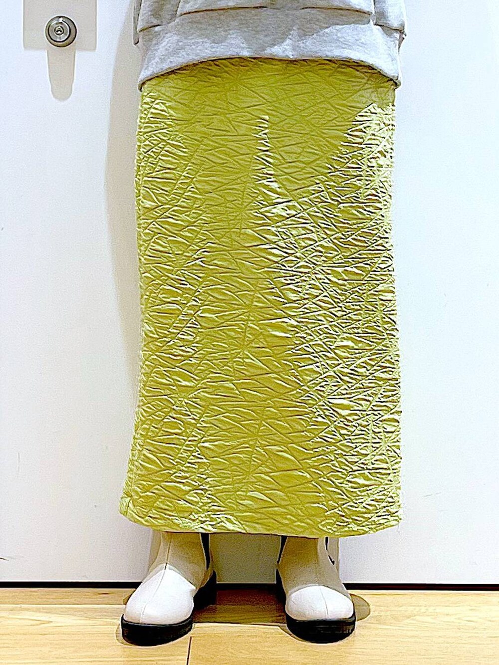 グリーン系のスカート、グレー系のスウェット、ホワイト系のショルダーバッグを着用したレディースの春コーディネートの8枚目の写真