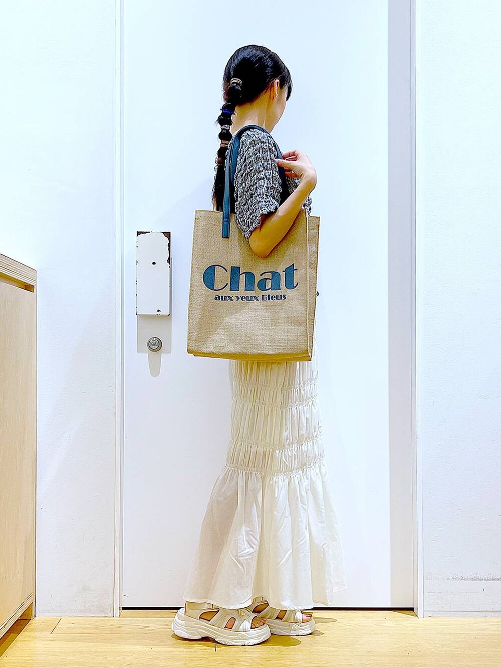 ホワイト系のサンダル、ブルー系のトートバッグ、その他のTシャツ/カットソーを着用したレディースの夏コーディネートの4枚目の写真