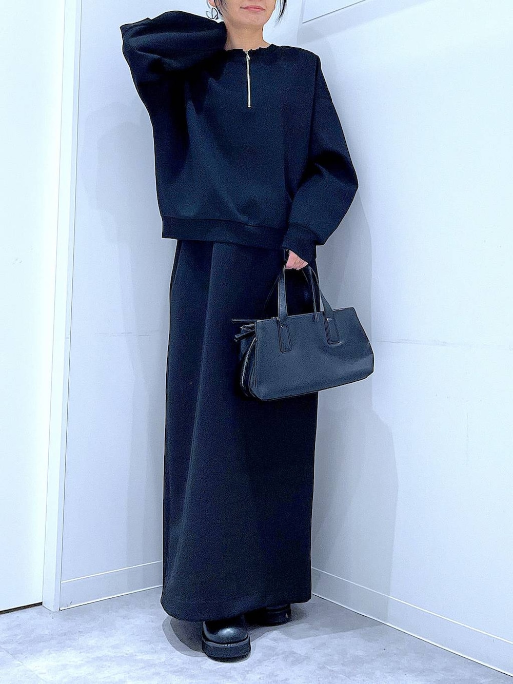 ブラック系のボストンバッグ、ブラック系のスウェット、ブラック系のスカートを着用したレディースの春コーディネートの6枚目の写真