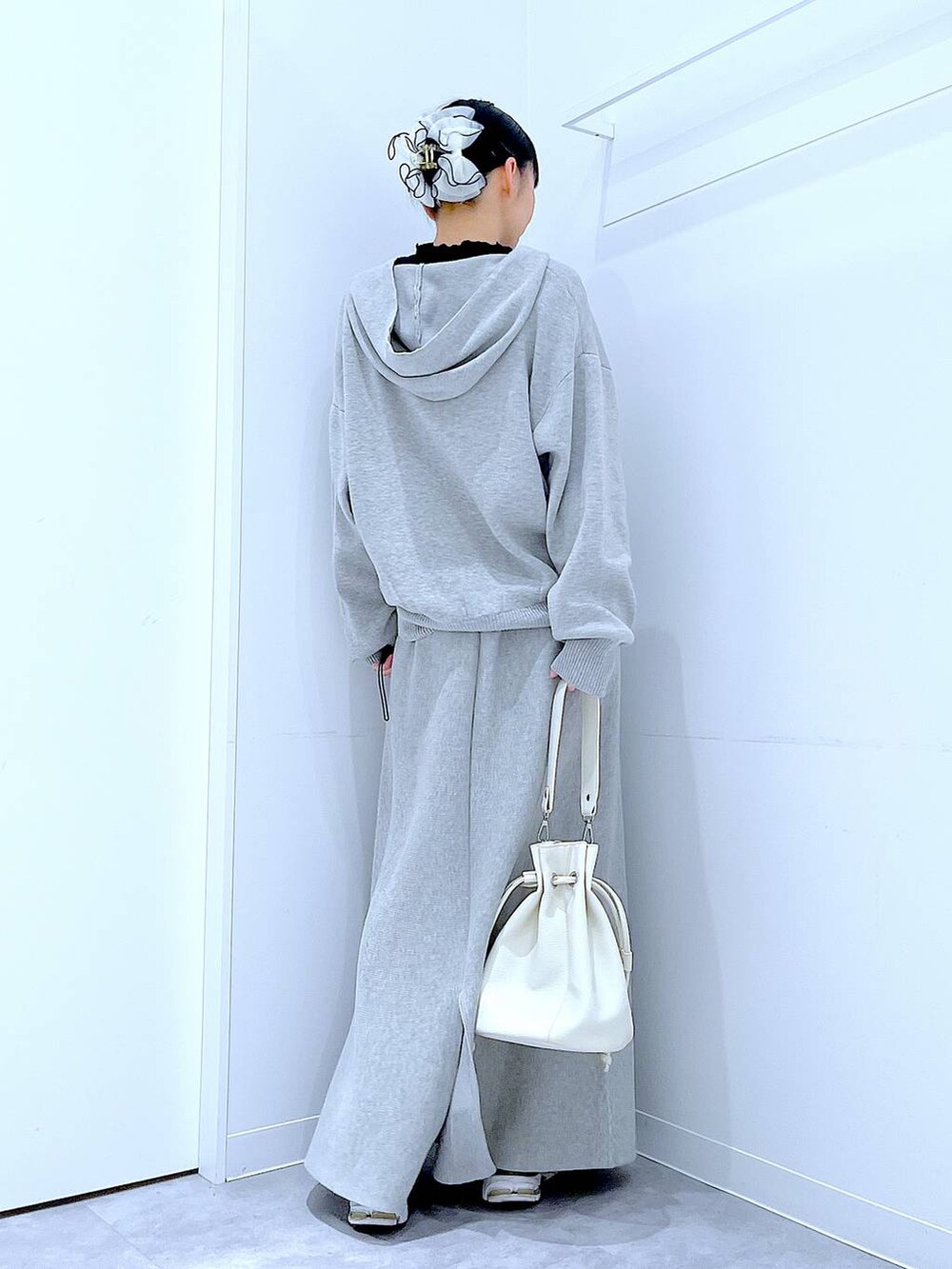 ブラック系のTシャツ/カットソー、グレー系のスカート、ホワイト系のショルダーバッグを着用したレディースの春コーディネートの5枚目の写真