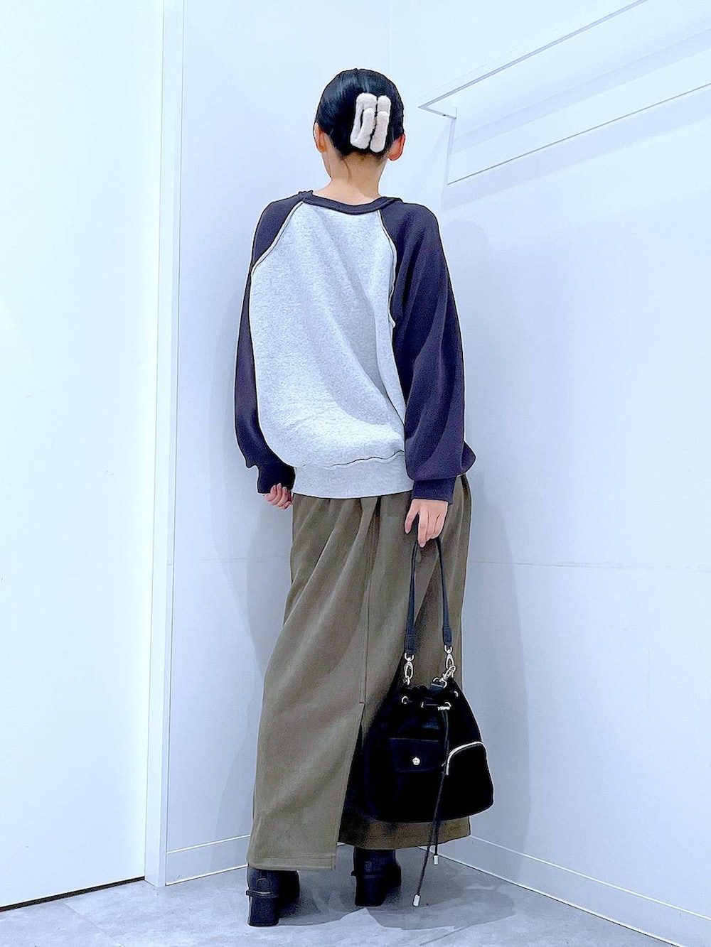 ブラック系のショルダーバッグ、グレー系のニット/セーター、ブラック系のブーツを着用したレディースの冬コーディネートの5枚目の写真