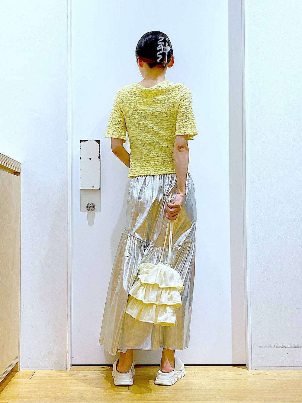 ホワイト系のサンダル、シルバー系のスカート、イエロー系のカーディガン/ボレロを着用したレディースの夏コーディネートの5枚目の写真