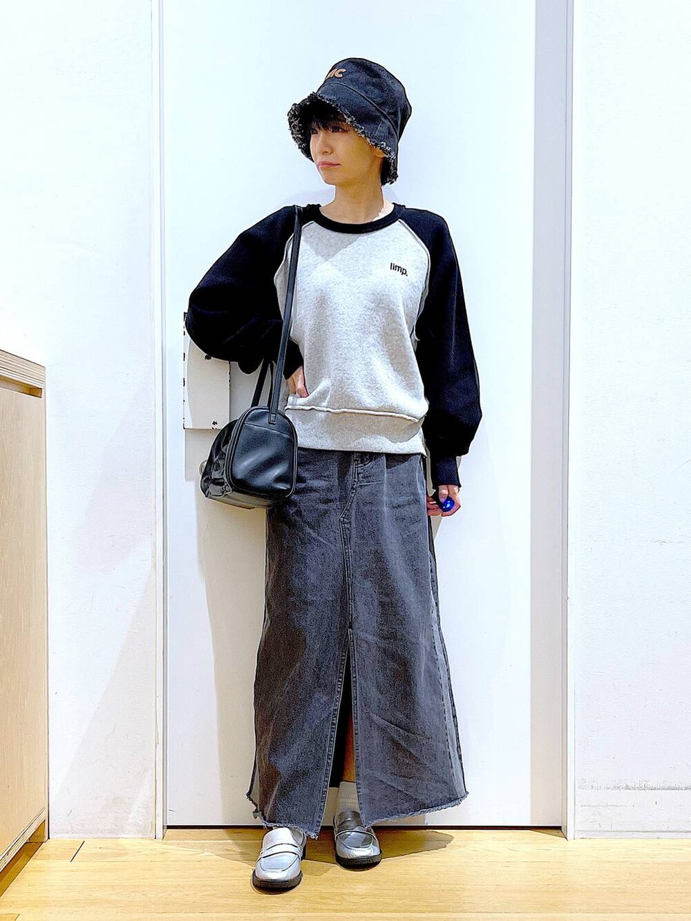 シルバー系のローファー、ブラック系のニット/セーター、ブラック系のショルダーバッグを着用したレディースの冬コーディネートの2枚目の写真