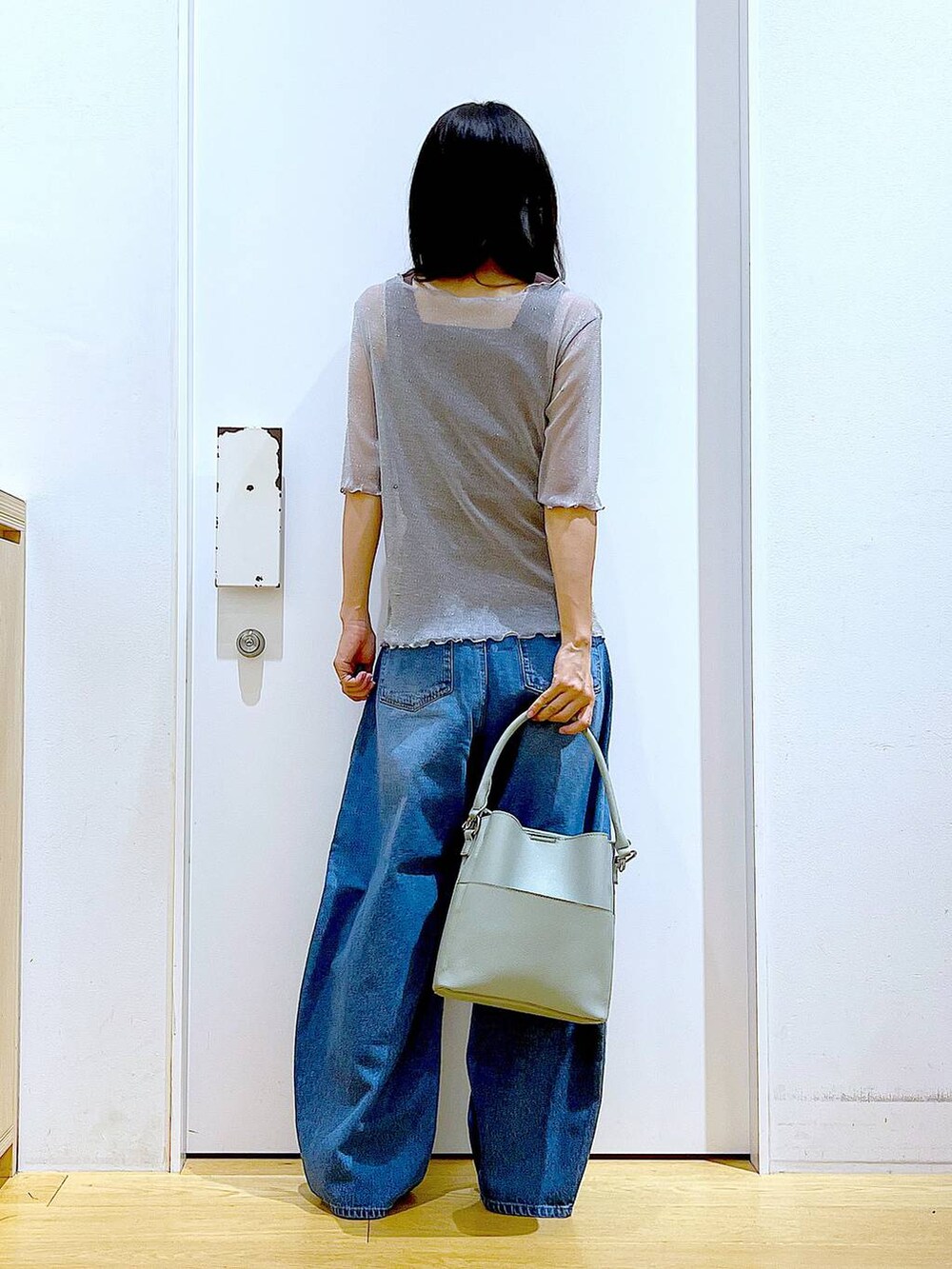 グレー系のTシャツ/カットソー、ブルー系のデニムパンツ、グリーン系のショルダーバッグを着用したレディースの秋コーディネートの5枚目の写真