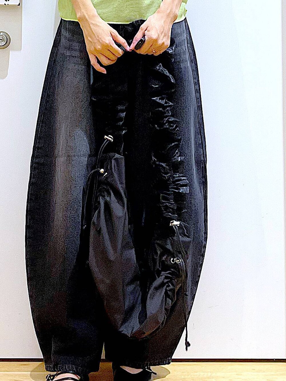 グリーン系のTシャツ/カットソー、ブラック系のデニムパンツ、ブラック系のパンプスを着用したレディースの秋コーディネートの9枚目の写真