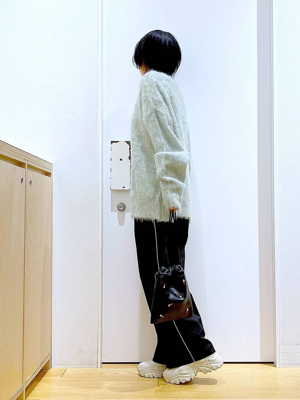 グリーン系のカーディガン/ボレロ、ブラック系のスラックス、ブラック系のショルダーバッグを着用したレディースの冬コーディネートの3枚目の写真