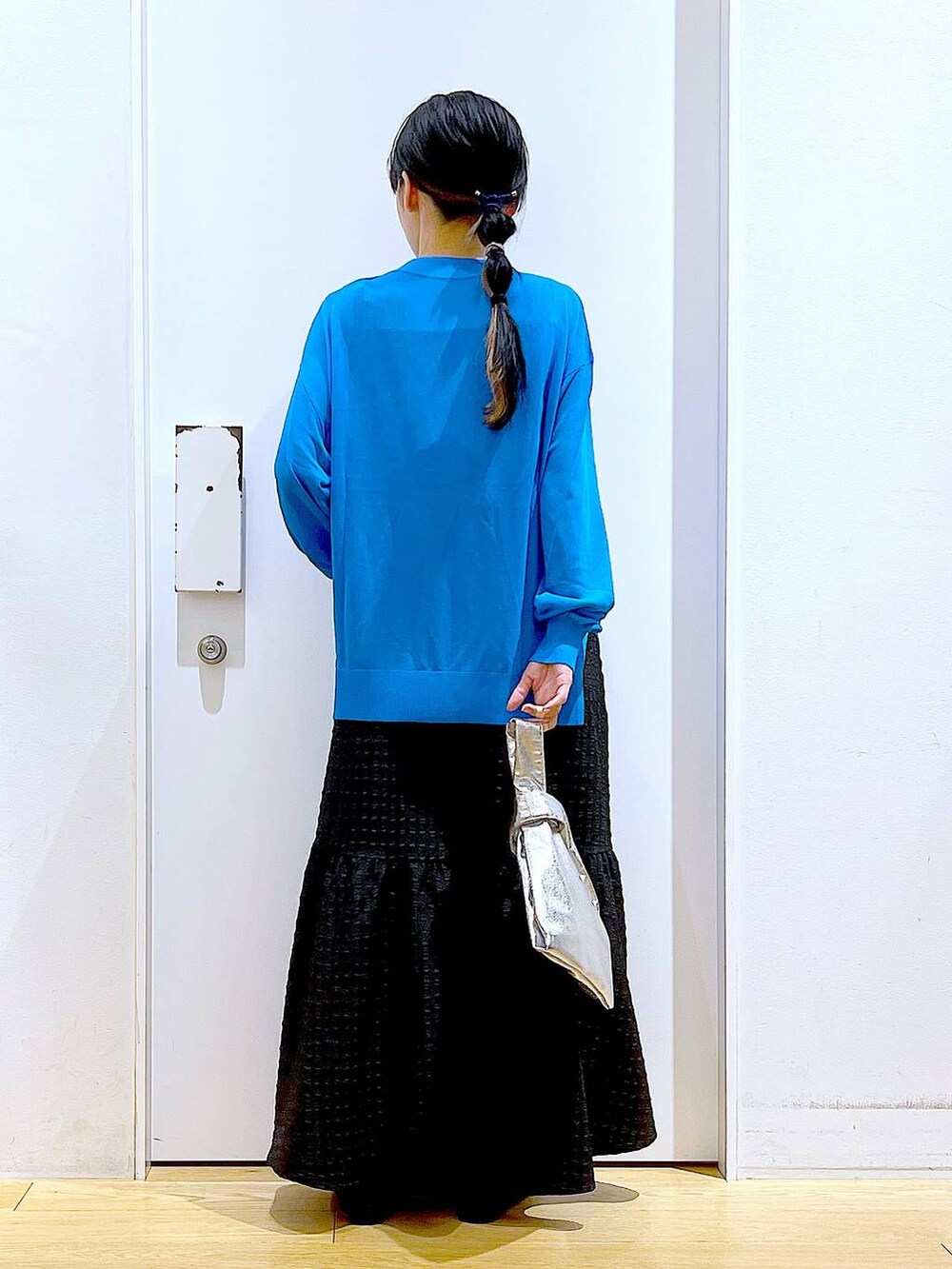 シルバー系のショルダーバッグ、ブラック系のワンピース、ブラック系のパンプスを着用したレディースの春コーディネートの5枚目の写真