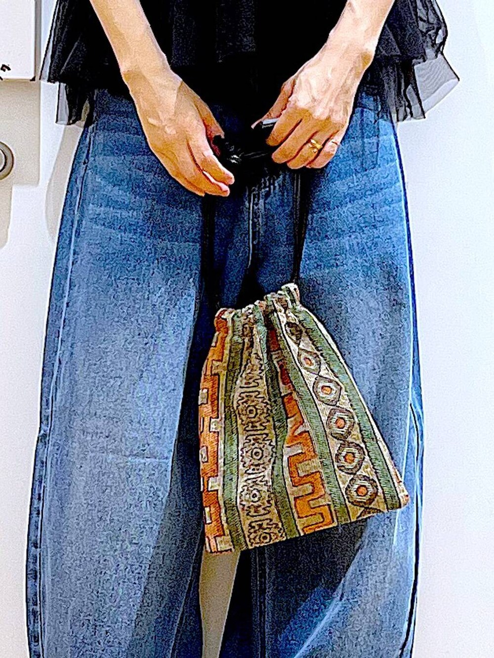 ブラウン系のショルダーバッグ、ホワイト系のサンダル、ブルー系のデニムパンツを着用したレディースの夏コーディネートの9枚目の写真