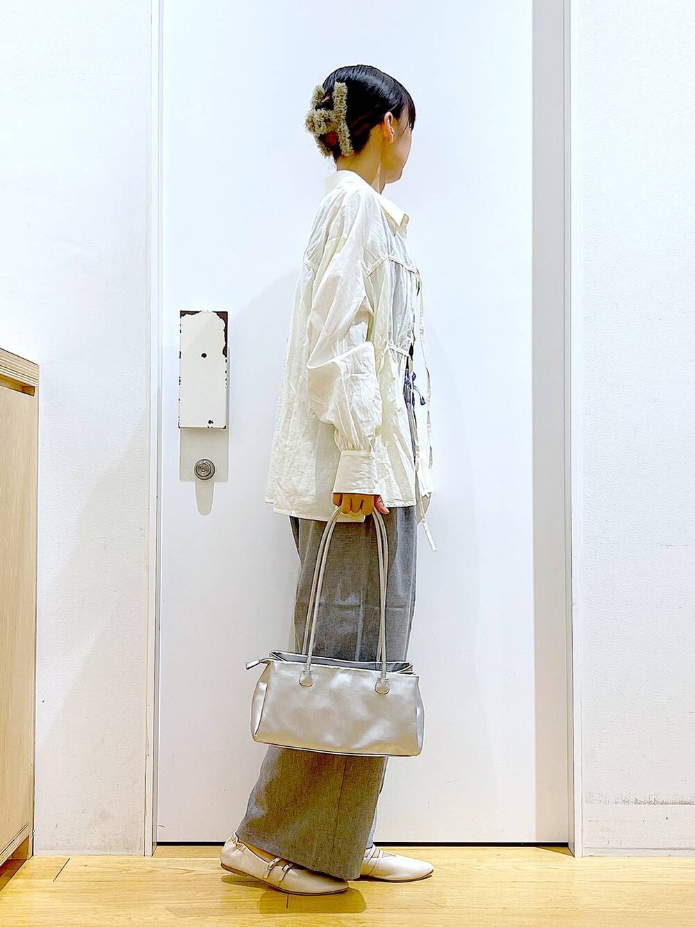 ホワイト系のパンプス、ホワイト系のシャツ/ブラウス、シルバー系のトートバッグを着用したレディースの秋コーディネートの4枚目の写真