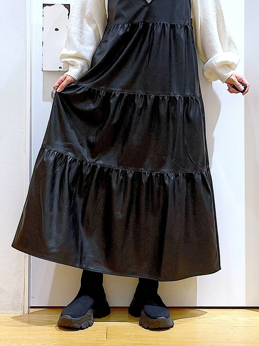 ブラック系のブーツ、ブラック系のワンピース、ピンク系のトートバッグを着用したレディースの冬コーディネートの8枚目の写真