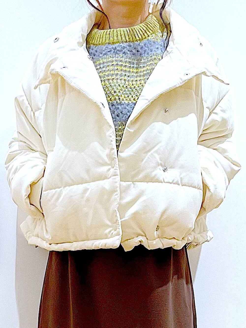 ベージュ系のショルダーバッグ、ブラック系のブーツ、ベージュ系のナイロンジャケットを着用したレディースの冬コーディネートの7枚目の写真